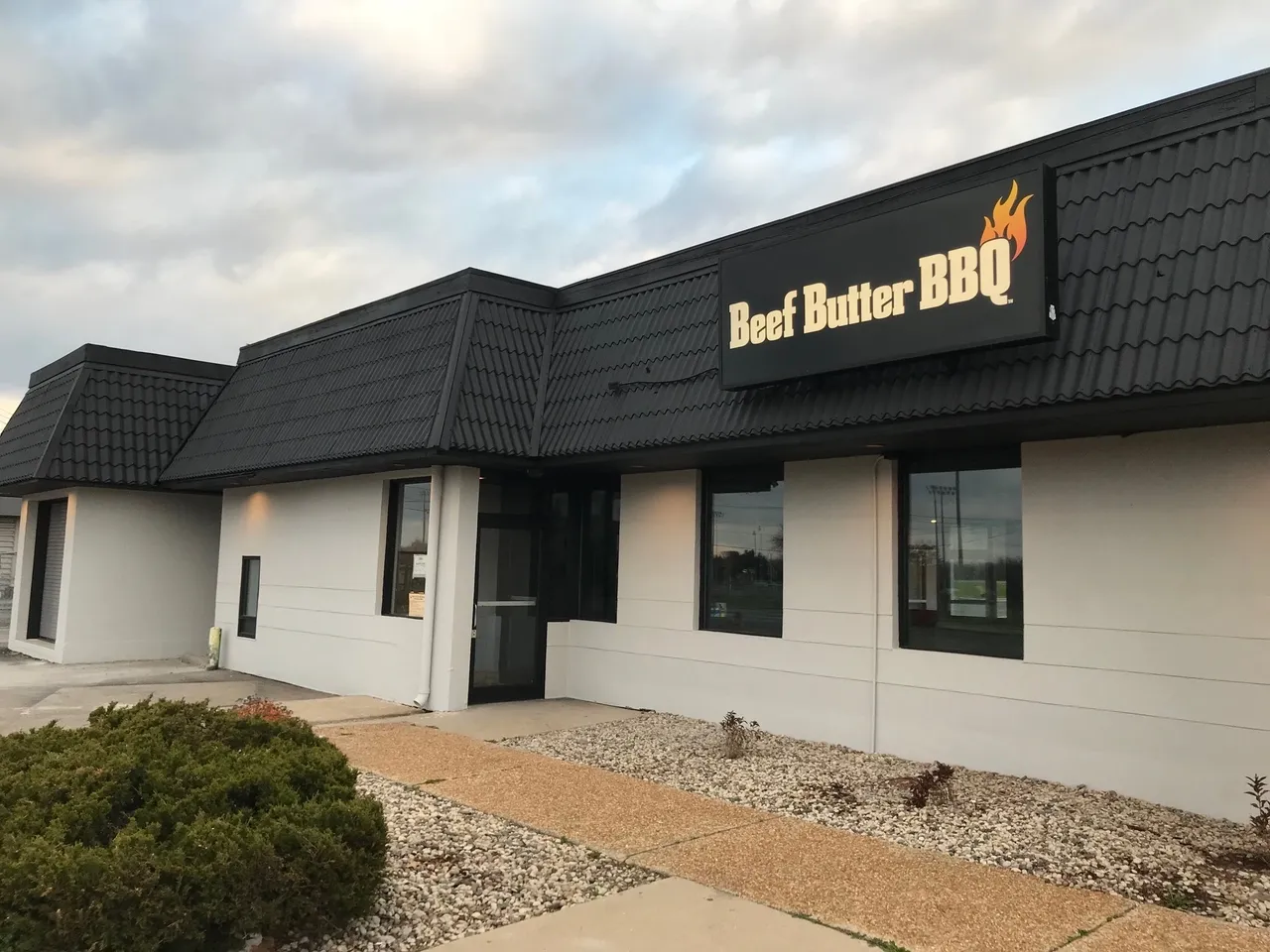 A building with a sign that says " beef better bbq ".