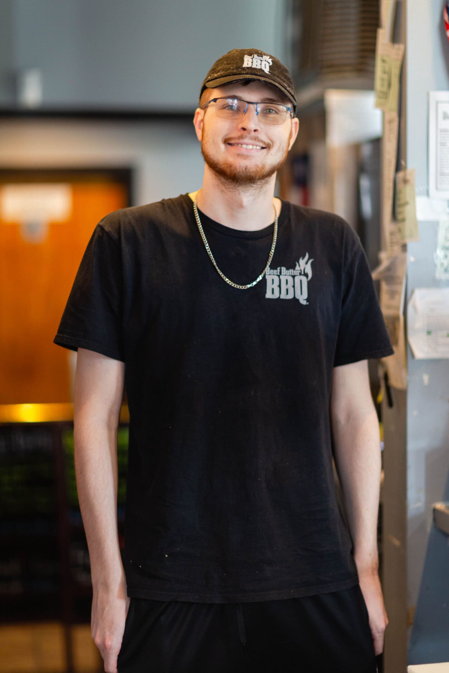 A man in black shirt standing next to metal door.