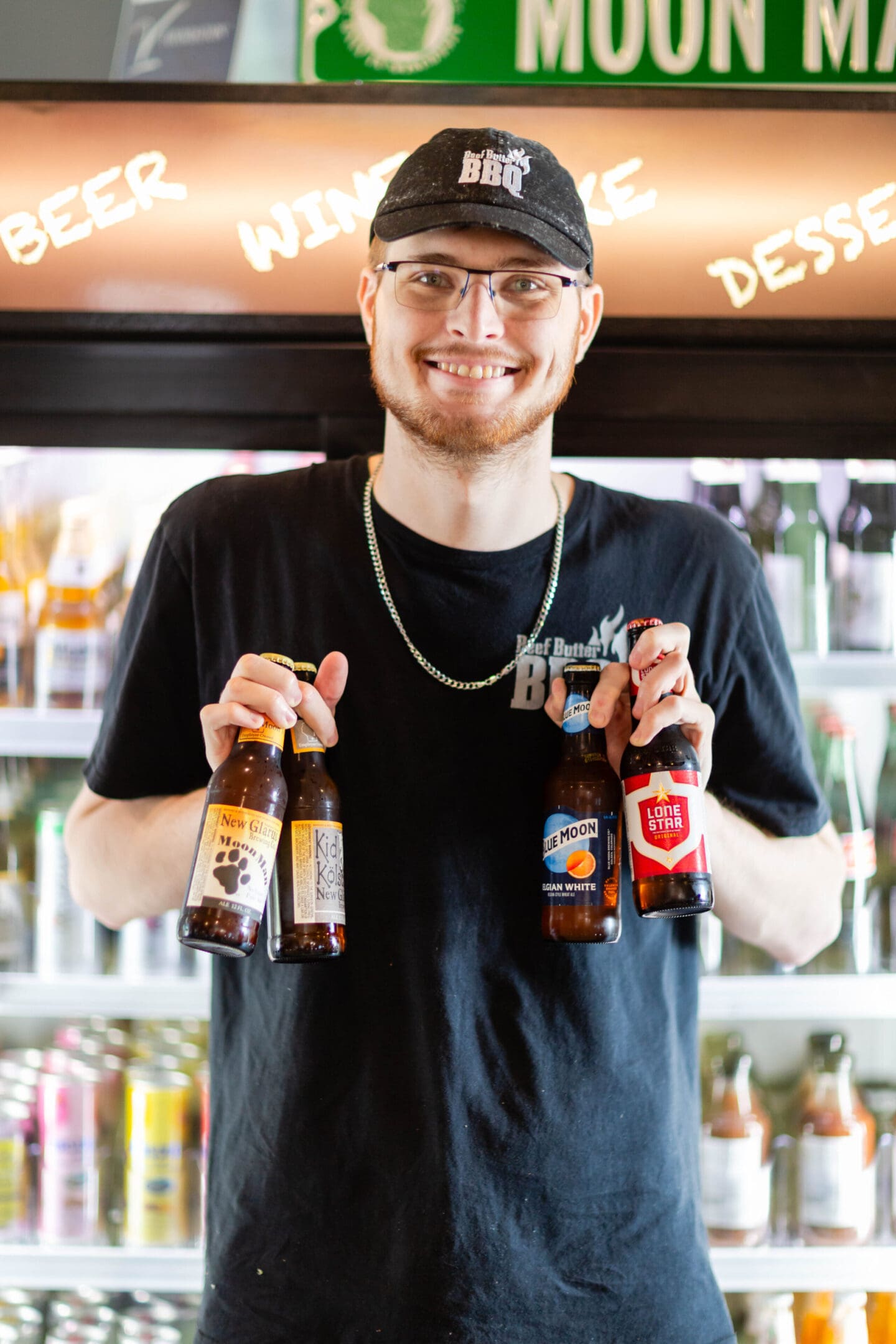 A man holding two beers in his hand.