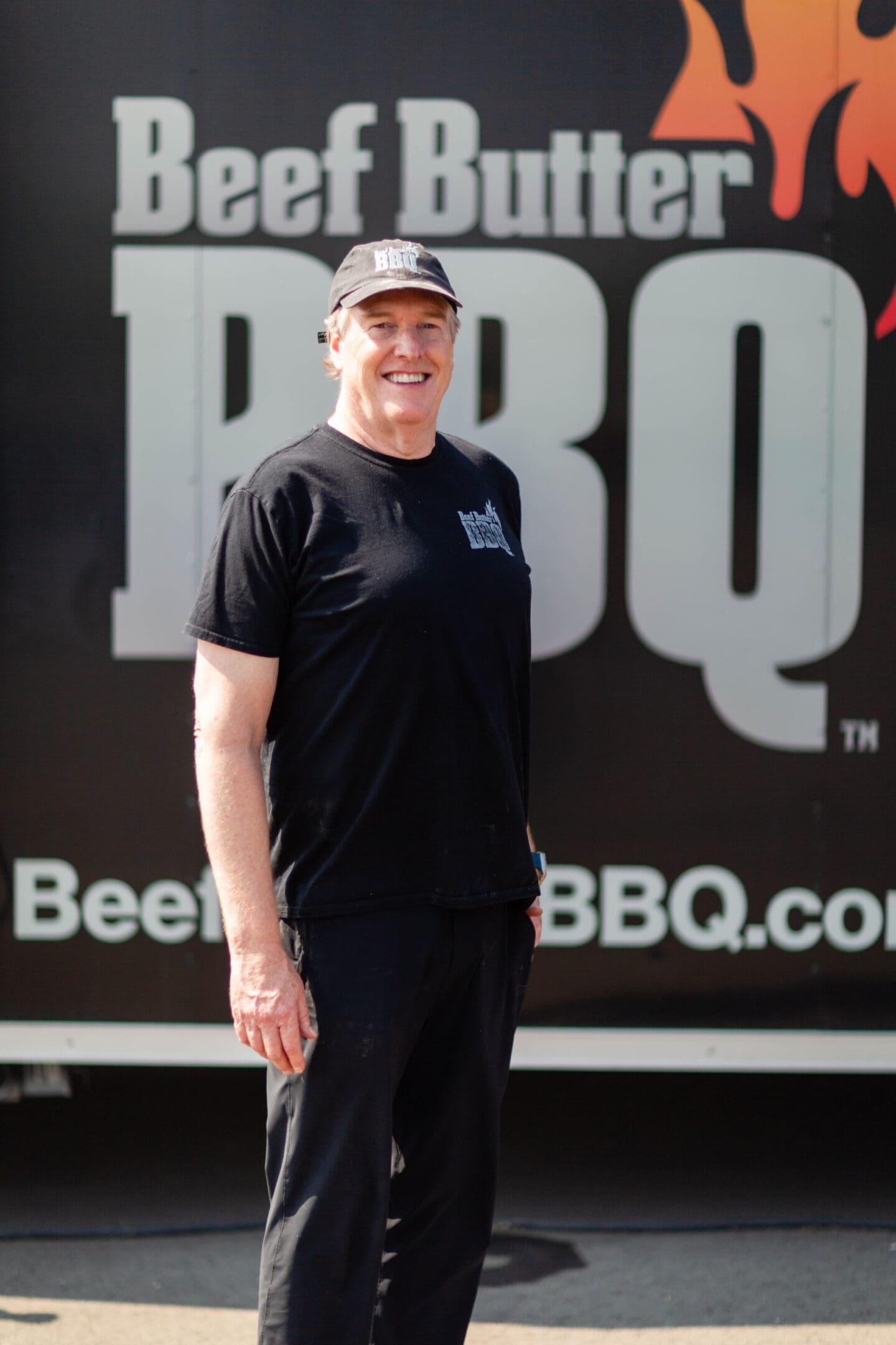 A man standing in front of a beer sign.