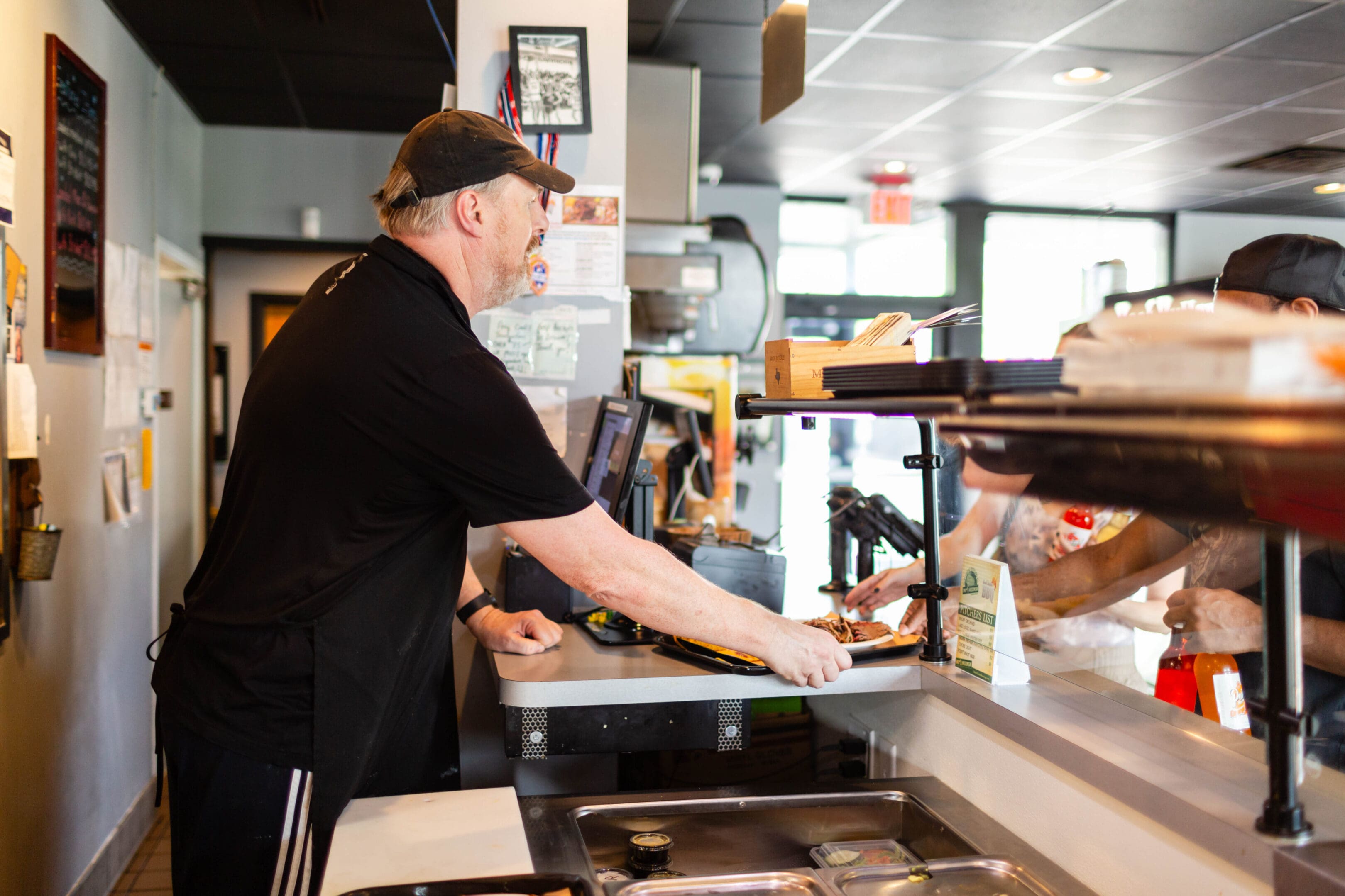 A man in black shirt standing at counter.