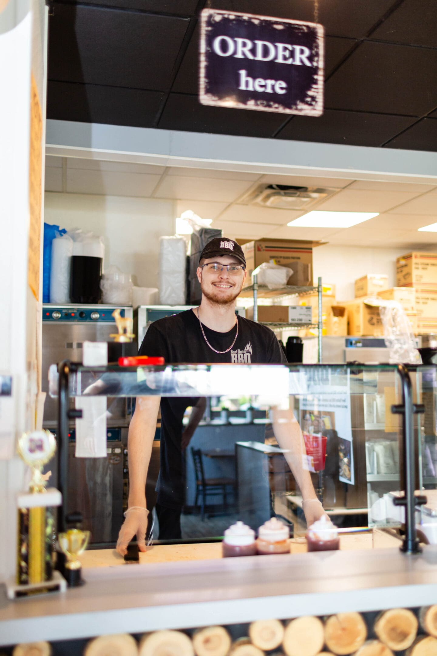 A man standing behind the counter of a restaurant.