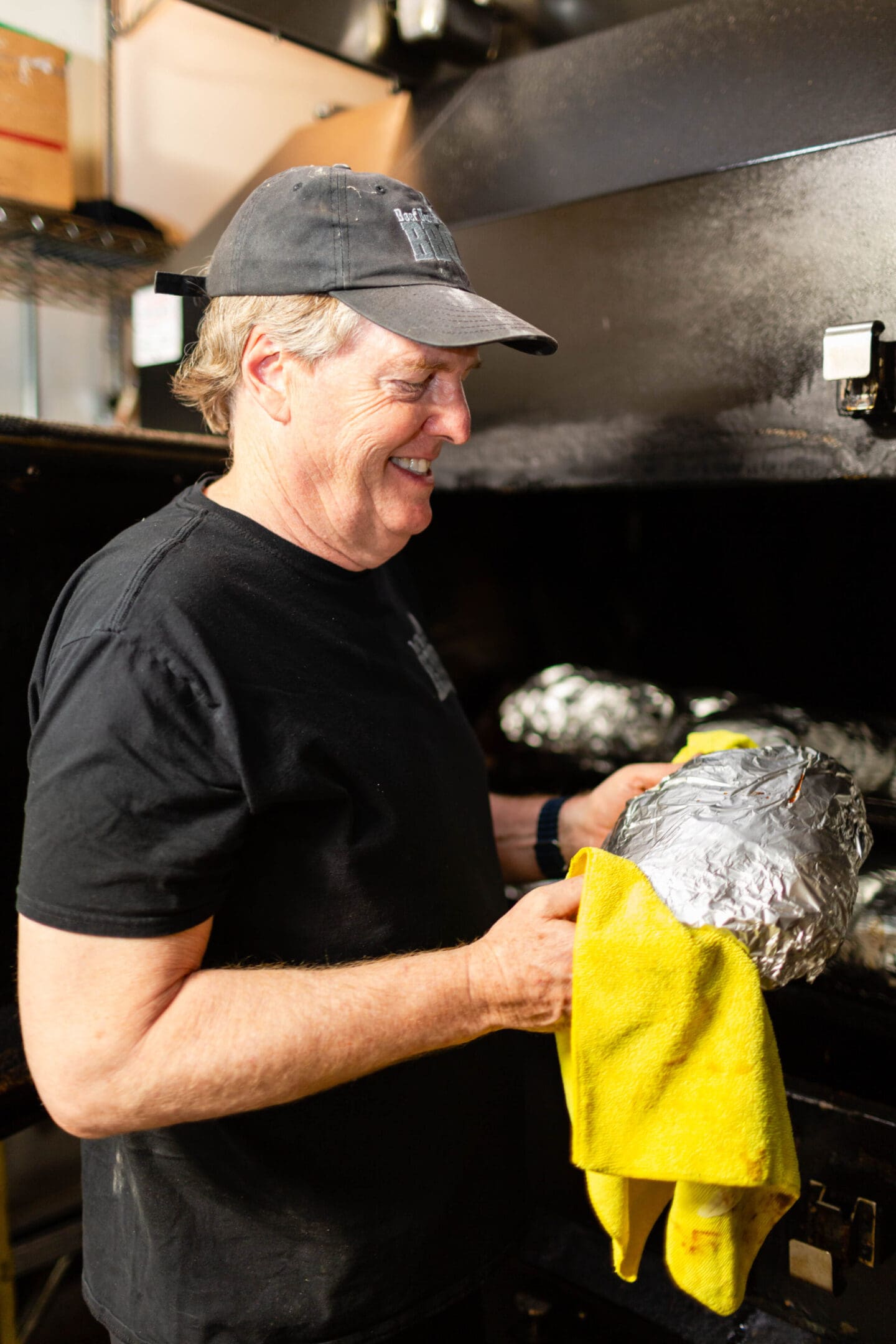 A man holding a yellow bag in front of an oven.