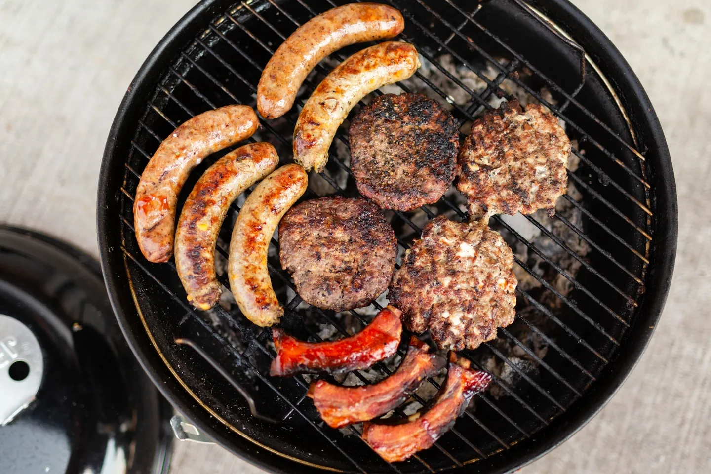 A grill with hamburgers and hotdogs on it.