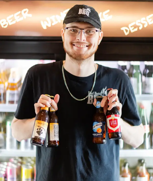 A man holding two beers in his hands.