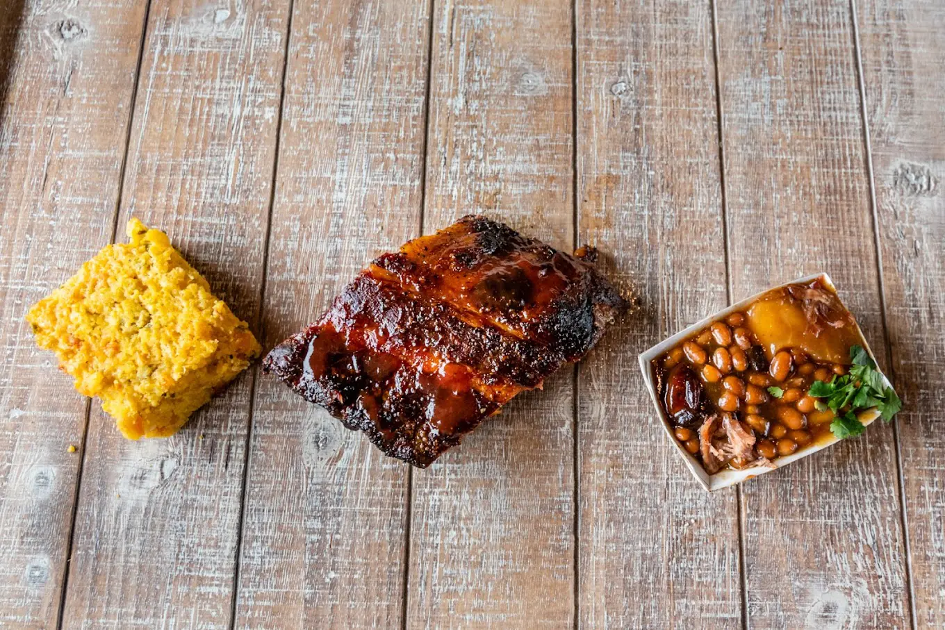 A wooden table with three different types of food.