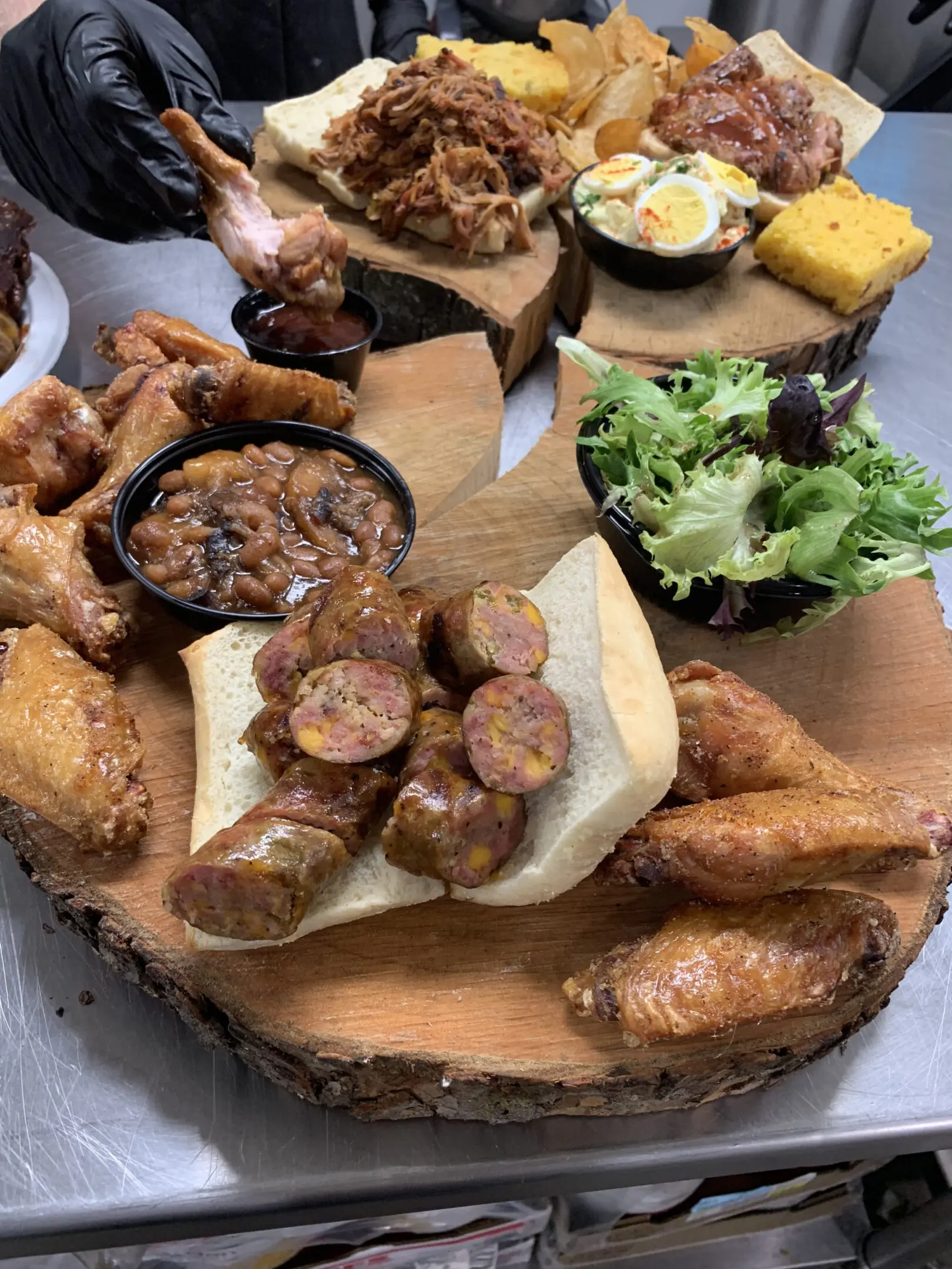 A wooden platter with various meats and sides.