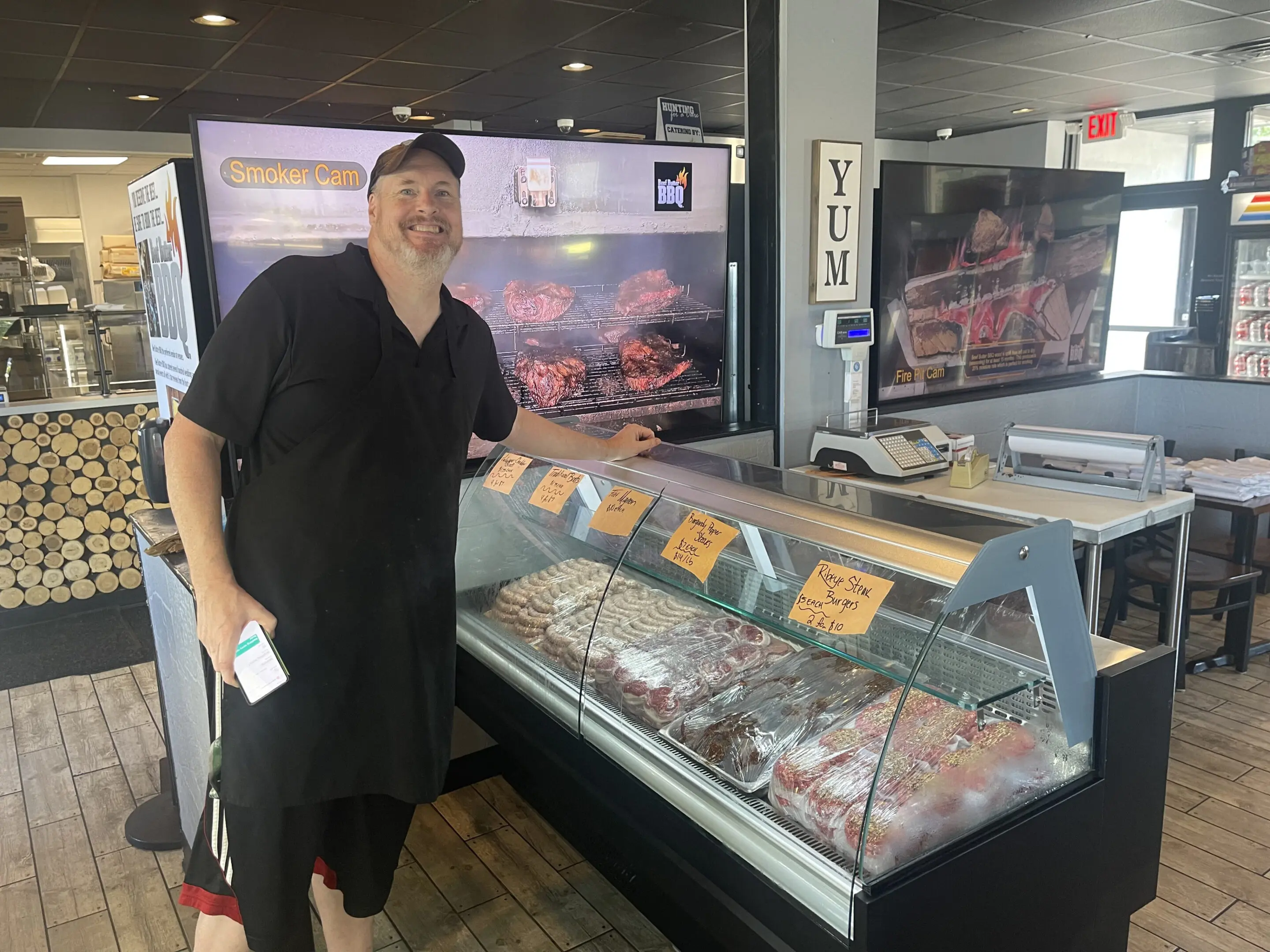 A man standing in front of an open grill.